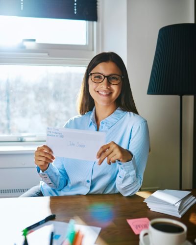 Happy woman in glasses holding envelope Happy woman in glasses holding envelope